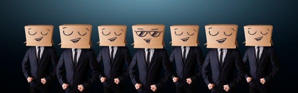 Handsome men in suit gesturing with drawn smiley faces on box