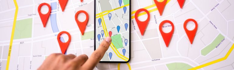 Landkaart met rode pins op telefoon ter illustratie van lokale SEO en vindbaarheid